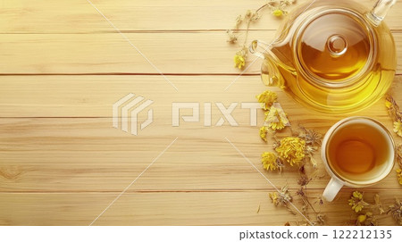 Warm herbal tea served in a cup beside a teapot and dried flowers on a wooden surface during a relaxing afternoon 122212135
