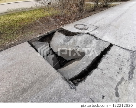 Large road pothole in urban area poses hazards to vehicles and pedestrians, close up view Large road pothole in urban area poses hazards to vehicles and pedestrians, close up view 122212820