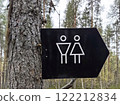 Sign indicating restroom facilities for men and women in a forested area. Comfortable environment in the park 122212834