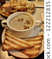 Delicious bowl of creamy mushroom soup with toasted bread served at a cozy restaurant in the evening 122212835