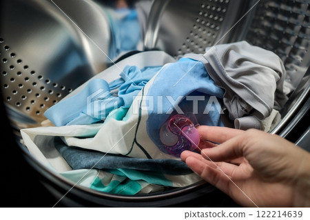 Using Laundry Detergent Pods While Doing Laundry in the Washing Machine with Clothes 122214639
