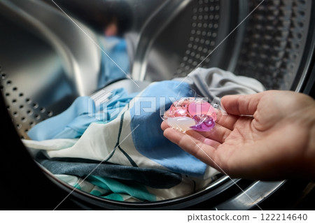 Using Laundry Detergent Pods While Doing Laundry in the Washing Machine with Clothes 122214640