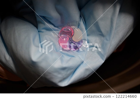 Using Laundry Detergent Pods While Doing Laundry in the Washing Machine with Clothes 122214660