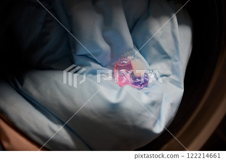 Using Laundry Detergent Pods While Doing Laundry in the Washing Machine with Clothes 122214661
