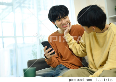 Affectionate gay couple relaxing together at home 122215140