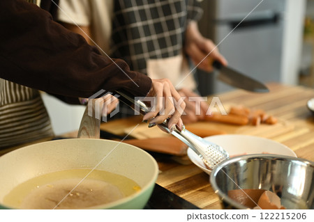 Close up of a gay couple preparing a meal in the kitchen Close up of a gay couple preparing a meal in the kitchen 122215206