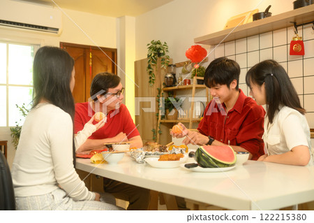 Happy Asian Chinese family enjoying traditional foods together during Chinese New Year Happy Asian Chinese family enjoying traditional foods together during Chinese New Year 122215380