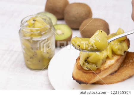 用湯匙舀起獼猴桃果醬 用湯匙舀起獼猴桃果醬 122215504