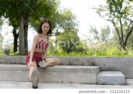 Young beautiful woman sportswear workout clothes exercise in street city park before morning run. Asian strong female sporty sportswear stretching outdoors. fitness healthy concept. 122216115