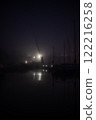 Night seaport. Light of lanterns reflects in water. Mystical place 122216258