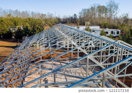 Workers construct metal beams roof framework in construction site 122217238
