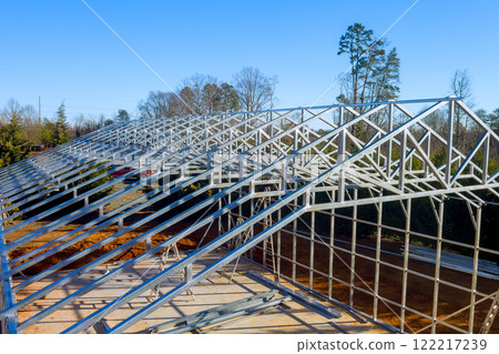 Large metal warehouse is under construction with steel framework, showcasing beams roof architecture 122217239