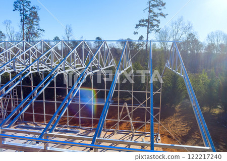 Workers are constructing sturdy it steel beams frame for new structure surrounded by metal warehouse 122217240