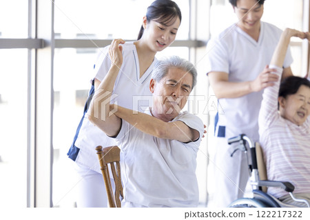 Caregiver: Seniors stretching with a physical therapist Caregiver: Seniors stretching with a physical therapist 122217322
