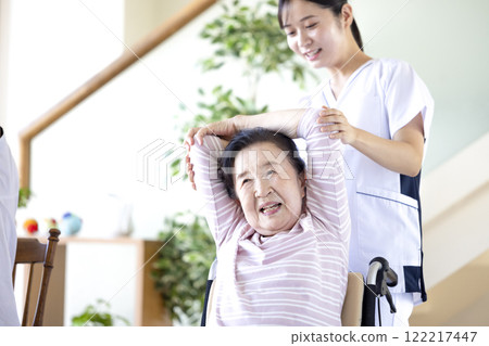 Caregiver: Seniors stretching with a physical therapist Caregiver: Seniors stretching with a physical therapist 122217447