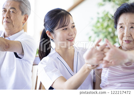 Caregiver: Seniors stretching with a physical therapist 122217472