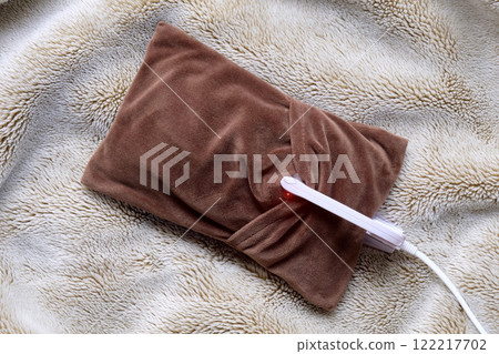 A heat storage hot water bottle on a blanket 122217702