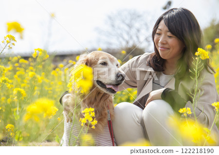 黃金獵犬和主人在油菜花田裡擁抱 黃金獵犬和主人在油菜花田裡擁抱 122218190