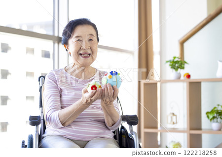 坐在輪椅上，看著她的智能手機的老婦人 122218258
