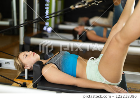 Blonde woman lies on the reformer platform Blonde woman lies on the reformer platform 122218386