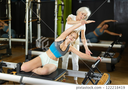 Trainer helps a woman do exercises 122218419