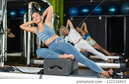 Woman doing bends on a reformer 122218433