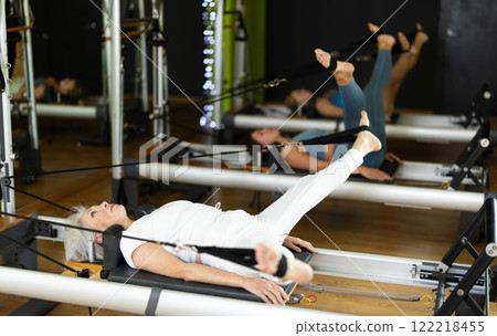 Mature slim woman lies on the reformer platform 122218455
