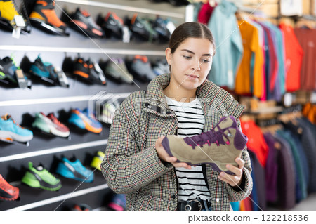 Girl examine compare item of winter comfortable tracking shoes 122218536