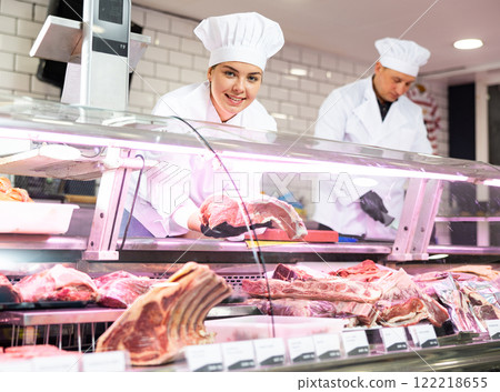 Young woman puts piece of beef in showcase 122218655