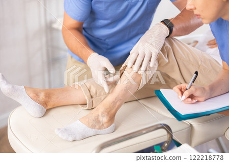 Doctor in medical gloves exam woman's legs. 122218778