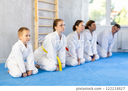 Family in gym at group karate training with trainer are in sitting position 122218827