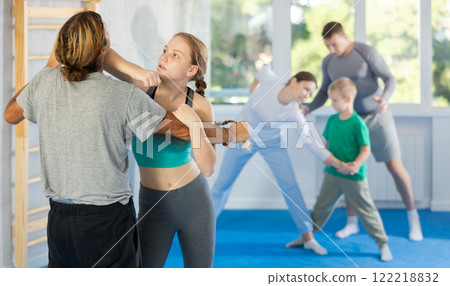 Teen girl in gym perform basic elements of krav maga self-defense system. Teen girl in gym perform basic elements of krav maga self-defense system. 122218832