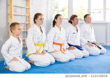 Family in gym at group karate training with trainer are in sitting position 122218916