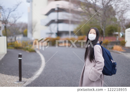 A young elementary school girl on her way to school in a residential area on a winter morning A young elementary school girl on her way to school in a residential area on a winter morning 122218935