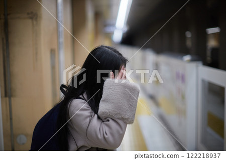 A young elementary school girl waiting for a train on a winter train platform A young elementary school girl waiting for a train on a winter train platform 122218937
