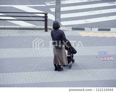 冬天,一位年輕的母親在大城市的人行道上等待紅綠燈 冬天,一位年輕的母親在大城市的人行道上等待紅綠燈 122218948