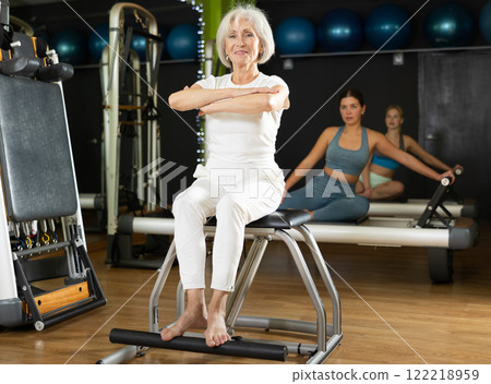 Mature woman doing exercises on a Pilates chair 122218959