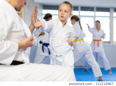Boy is paired with man teacher to learn how to strike and rehearses blocking opponent Boy is paired with man teacher to learn how to strike and rehearses blocking opponent 122218967