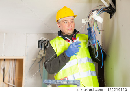 Electrician working with wires in apartment Electrician working with wires in apartment 122219110