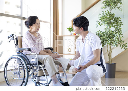 Medical: Senior woman receiving a medical examination from a physical therapist 122219233