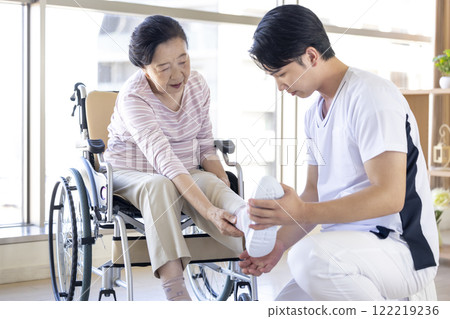 Medical: Senior woman receiving a medical examination from a physical therapist 122219236