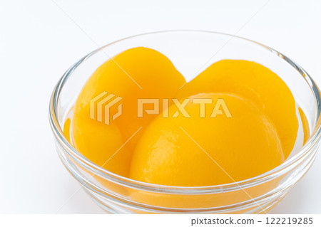 Canned yellow peaches in a glass container 122219285