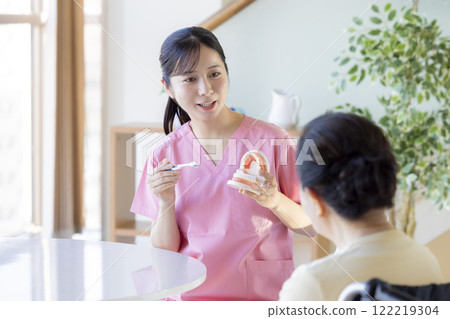 老年婦女接受牙科保健員的刷牙指導 122219304