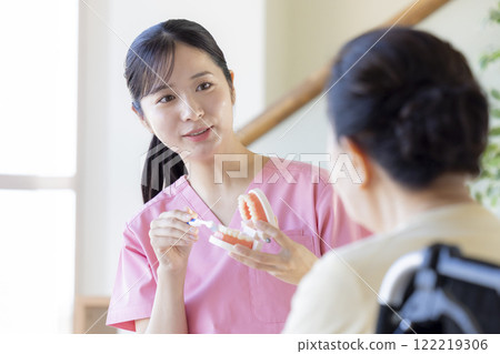 老年婦女接受牙科保健員的刷牙指導 老年婦女接受牙科保健員的刷牙指導 122219306