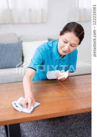 Senior female housekeeper cleaning the table Senior female housekeeper cleaning the table 122219361