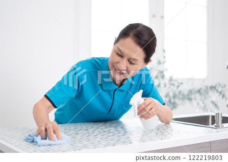 Senior female housekeeper cleaning the kitchen 122219803