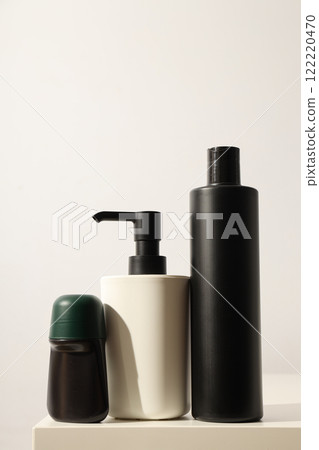 Bottles with men's cosmetics and dispenser on light background Bottles with men's cosmetics and dispenser on light background 122220470
