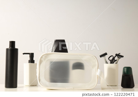 Bottles with men's cosmetics and razors in glass on light background, space for text Bottles with men's cosmetics and razors in glass on light background, space for text 122220471