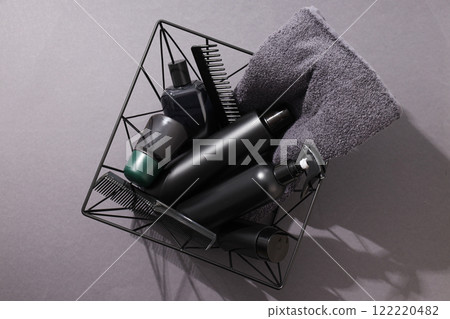 Bottles with men's cosmetics, combs and towel in basket on gray background, top view 122220482