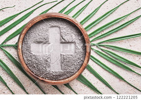 Cross in ashes on a palm leaf background - symbols of Ash Wednesday Cross in ashes on a palm leaf background - symbols of Ash Wednesday 122221205